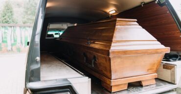 Caixão dentro do carro fúnebre representa quando solicitar o traslado de corpos